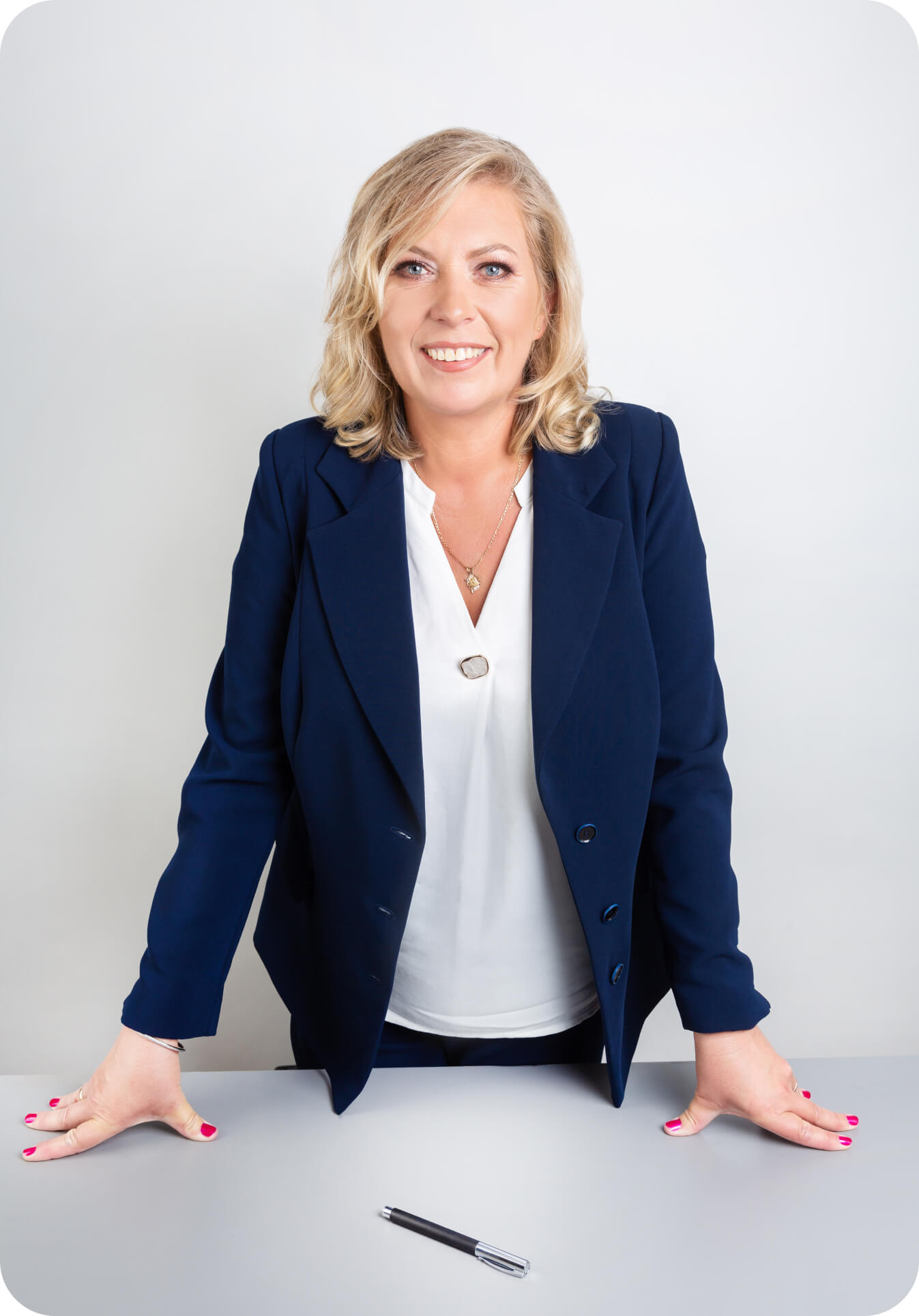 Anna Wąsowicz stojąca przy biurku z szerokim i szczerym uśmiechem.