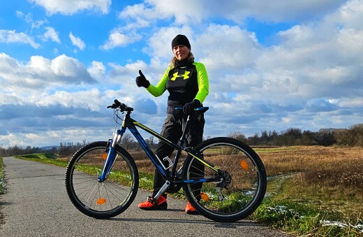 Anna Wąsowicz z rowerem, promując zdrowy styl życia i aktywność fizyczną.