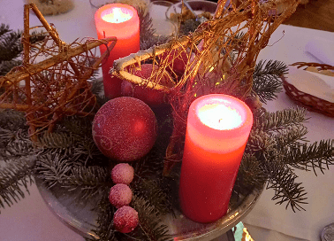 Świąteczne dekoracje z czerwonymi świecami i ozdobami na bożonarodzeniowym stole